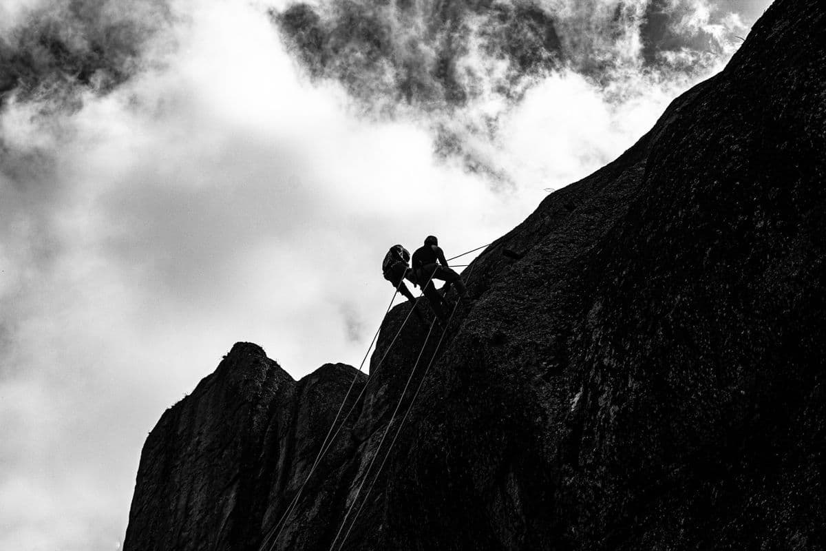 Mountaineers climbing with ropes on rock